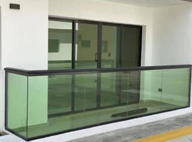 Baranda de aluminio negro con vidrio verde en un balcón