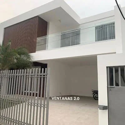 Casa con baranda de vidrio en la terraza del segundo nivel