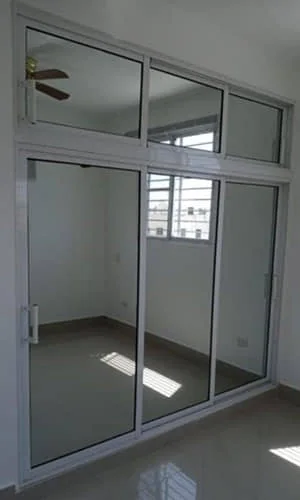 Puertas correderas de vidrio con perfil de aluminio en una habitación